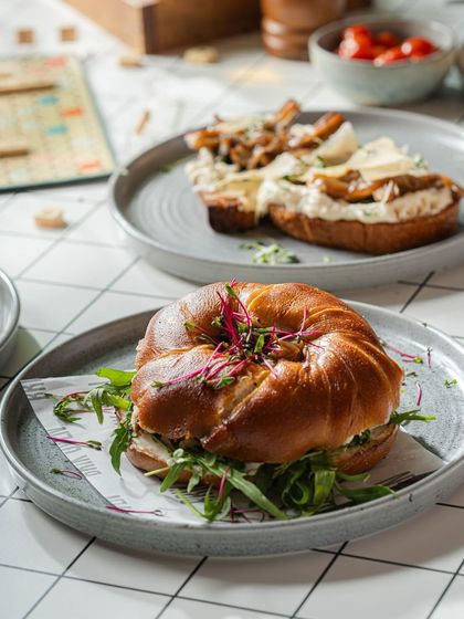 A beautiful breakfast spread featuring our pretzel bagel sandwich and a wild mushroom toast, perfect for sharing or for a very hungry individual.