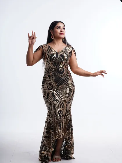 An elegant pose in the black and gold sequin gown, showing off its beautiful silhouette and intricate pattern.