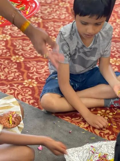 A child participating in 'phoolon ka havan' (a floral offering) during our Shiva workshop in Dayton. It's a beautiful, sensory way to engage in prayer.