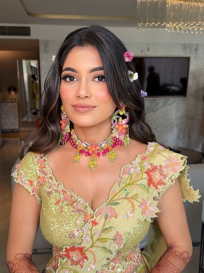 A close-up of the bride, her floral-adorned hair and colorful jewelry creating a stunning and vibrant Mehendi look.