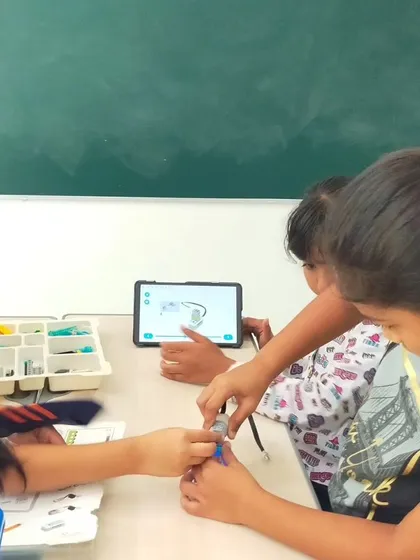 Students at TSGM use a tablet to visualize and build a complex LEGO model. Digital tools are integrated into our curriculum to enhance the learning experience.