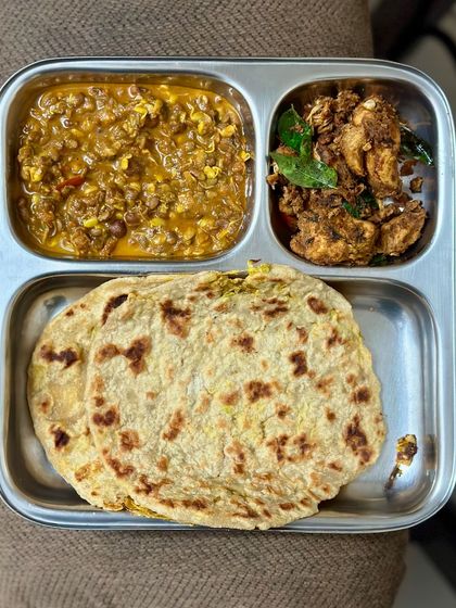 This high-protein meal features cabbage-stuffed roti with horse gram dal and a side of chicken 65.