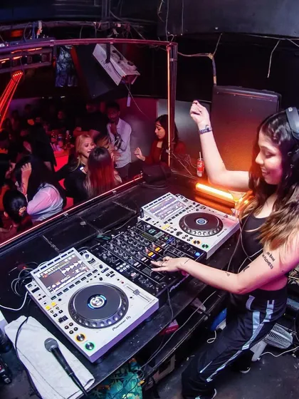 A wide shot showing the full setup and the crowd at a club in Kolkata. I'm experienced with professional-grade Pioneer DJ equipment for any venue.