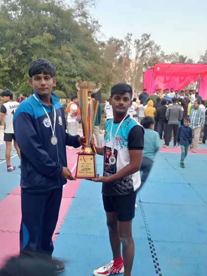 Two of our players proudly holding the trophy after a tough competition. This picture represents the brotherhood and teamwork we foster in our academy.