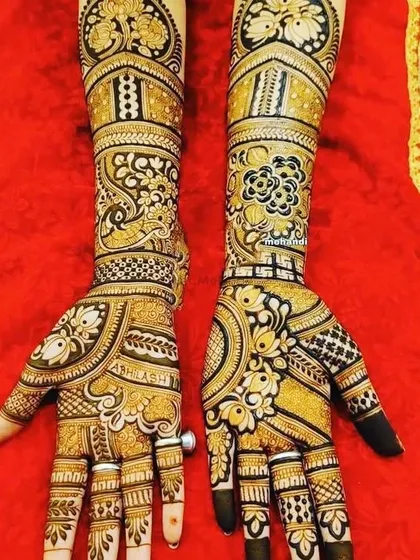 A gorgeous design featuring peacocks and floral patterns with bold shading. The dark fingertips are a classic part of bridal mehndi.