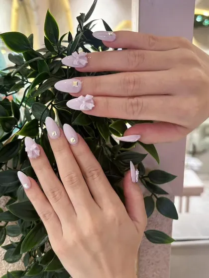 A full view of the delicate 3D bow nail art, showing how beautifully they complement the elegant almond nail shape.