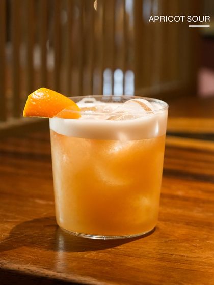 The Apricot Sour, a stone fruit twist on a classic. This cocktail is smooth, slightly sweet, and perfectly tangy, making it a crowd-pleasing choice.