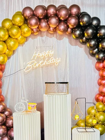 A close-up view of the multi-colored chrome balloon arch. The blend of different metallic shades gives the decoration a rich and festive look.