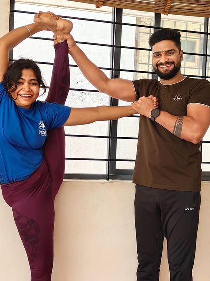 Working together to perfect the standing split (Urdhva Prasarita Eka Padasana). My support provides stability, allowing the student to focus on hip flexibility and balance.