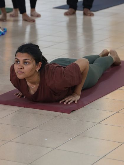A student practices Bhujangasana, the cobra pose, one of the 12 postures in the Surya Namaskar sequence. We teach the correct breathing and technique for each step.