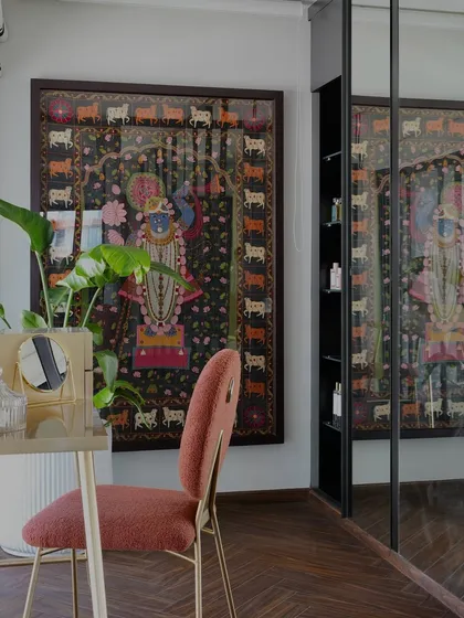 This spacious walk-in wardrobe is an extension of the master bedroom in the Evelyn project. It features mirrored shutters to enhance the sense of space and a handmade art piece of Lord Shrinathji that adds a divine and personal touch.