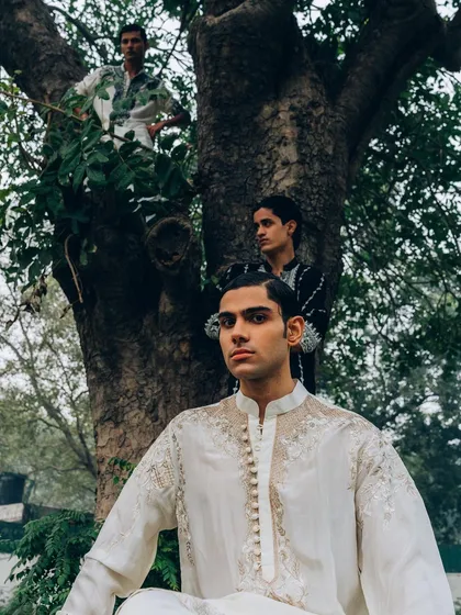 An outdoor editorial for menswear designer Sanchit Sharma. The composition uses the natural environment, with models placed within a tree to create a unique, layered image.