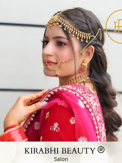 A side profile of a beautiful bride, highlighting the intricate matha patti and nose ring. The makeup is kept classic and clean to enhance her features without overpowering the traditional jewelry.
