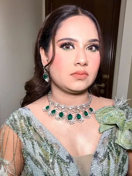 A close-up of this client's engagement look, featuring a beautiful emerald and diamond necklace.