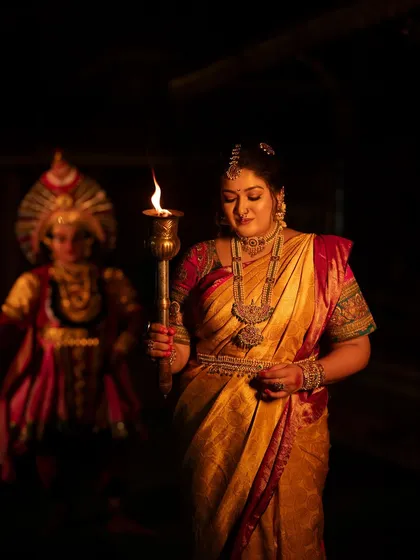 A close-up on the subject's face, her expression illuminated by the torchlight, conveying a mix of strength and serenity.