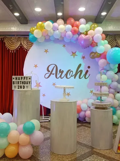 A colorful pastel balloon arch against a circular backdrop for a second birthday.