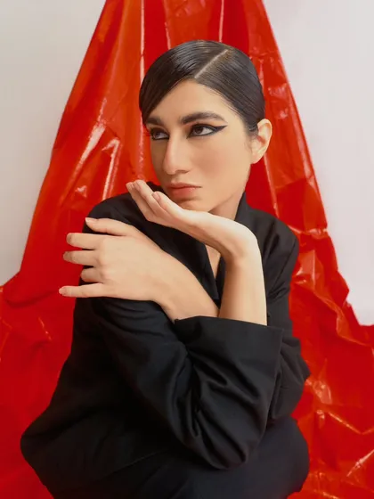 A contemplative, seated portrait from the same series. The model's pose and expression add a layer of emotional depth to the fashion story.