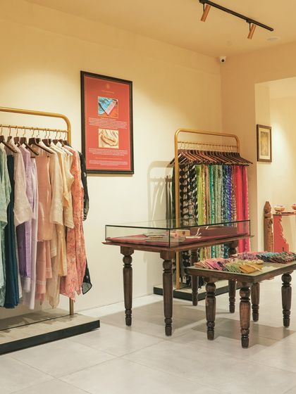 A different angle of the clothing display area, showing how we used framed art and minimalist fixtures to create a gallery-like feel.