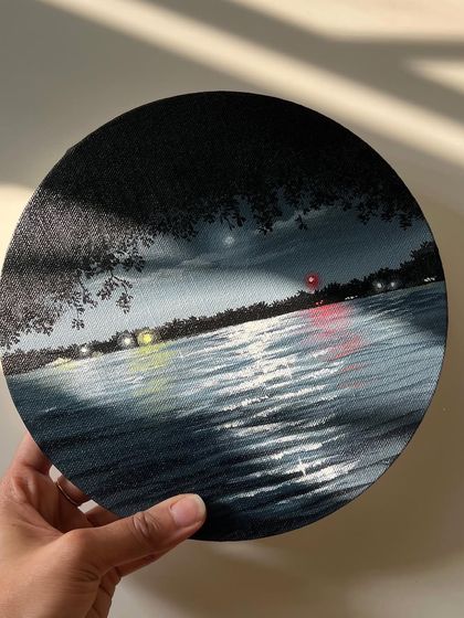 Holding the finished round nightscape painting.