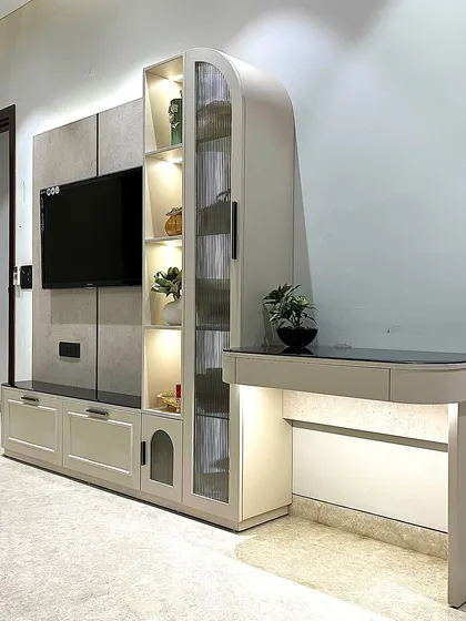 We believe in furniture that is both beautiful and functional. This sleek TV unit integrates a display cabinet with fluted glass and a compact study nook with its own lighting, making it a perfect multi-functional piece for modern living.