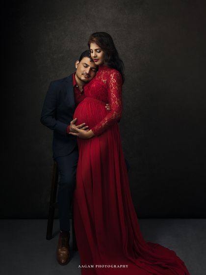 A tender moment captured. The father-to-be rests his head on her shoulder, a gesture of love and support that tells a beautiful story.