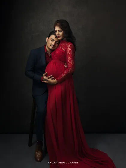 A tender moment captured. The father-to-be rests his head on her shoulder, a gesture of love and support that tells a beautiful story.
