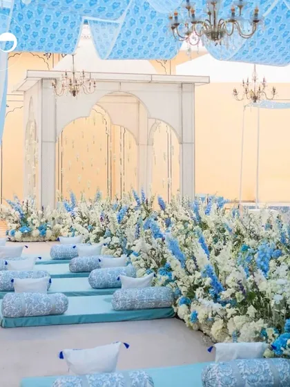 We transformed this space into a summer dream with flowing blue fabrics, elegant chandeliers, and a stunning field of flowers. This setup features both traditional low seating with bolsters and classic chair arrangements to create a comfortable and breathtaking experience for everyone.