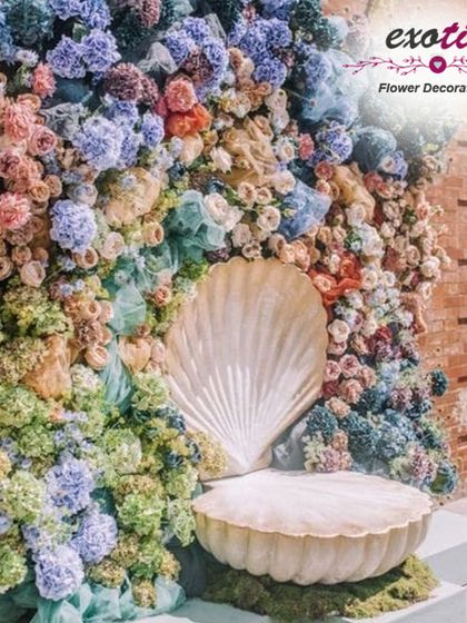 A whimsical, seashell-themed throne for Ganpati. This unique design uses a pastel palette of hydrangeas and roses to create an under-the-sea look for Bappa.