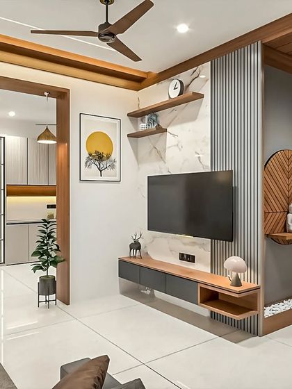 An open-concept living area design that flows into the kitchen. The TV unit is paired with a decorative wall niche for a Buddha statue, blending modern design with serene, personal touches.