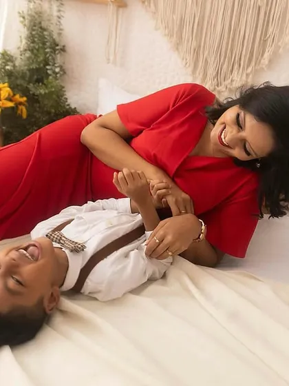 The best sound in the world is a child's laughter. This playful moment on the bed shows the pure joy between a mother and her son.