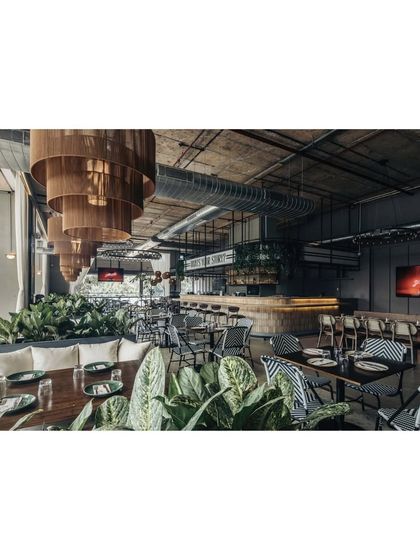 This overall view shows how we created a lounge-style atmosphere reminiscent of the outdoors. We retained the original high ceiling to allow natural light to flood the space, with the bar as the main focal point.