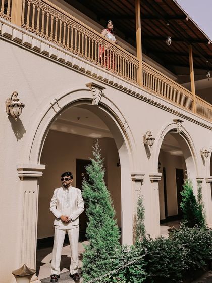 A creative portrait using the venue's architecture. I placed the bride on the balcony above the groom, creating a visually interesting composition that feels like a scene from a classic romance.