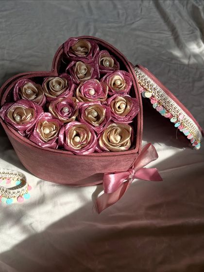 Another beautiful angle of the heart-shaped rose box. The soft lighting highlights the shimmer of the satin and the luxurious feel of the gift.