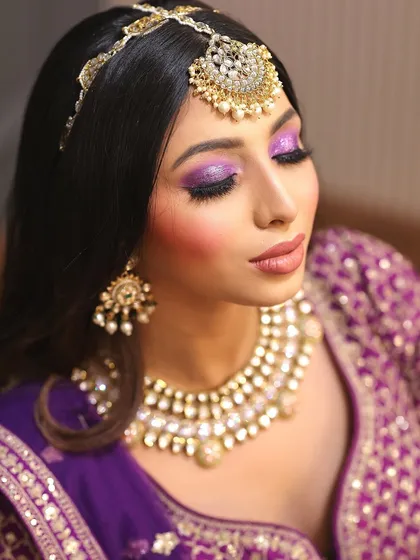 A close-up with eyes closed, highlighting the blend of purple shimmer on the eyelids.