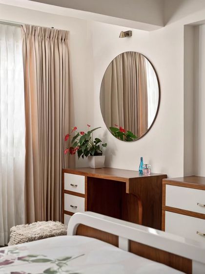 The sleek dressing table with a large circular mirror in the master bedroom corner. This addition enhances the room's functionality while maintaining a clean, uncluttered aesthetic.