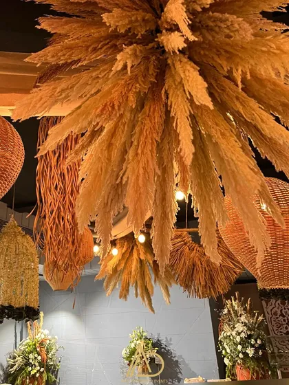 A statement ceiling installation made from pampas grass and assorted woven lanterns, which became a major focal point of the decor.