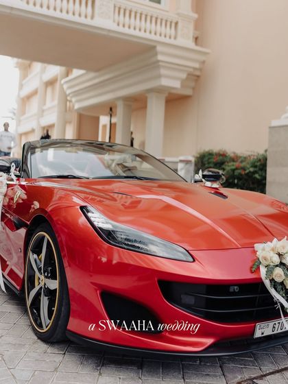 A baraat that turns heads starts with the right ride. A flower-adorned red Ferrari makes a bold statement, perfectly blending modern luxury with the traditional groom's procession at a palace wedding.