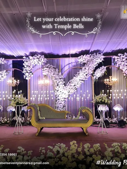 A sophisticated and modern reception stage design. We used a color palette of white and lavender, with cascading floral arrangements, elegant chandeliers, and soft backlighting to create a dreamy, romantic ambiance.