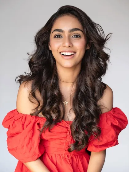A joyful and energetic portrait. I created a dewy makeup look with voluminous curls for this model in a bright red dress, resulting in a fresh and youthful feel.