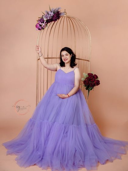 A graceful solo portrait using the golden birdcage prop. The soft lavender gown and floral accents create an ethereal and elegant look.