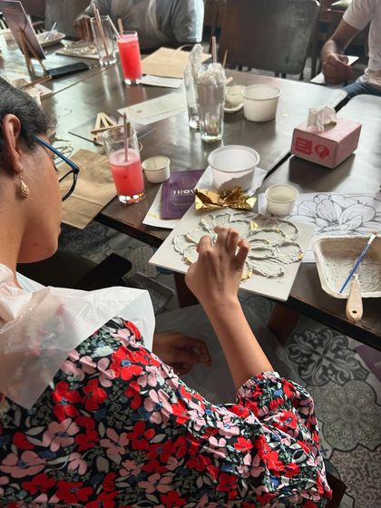 A participant engrossed in the process of creating her textured flower. It's a moment of pure focus and creativity.