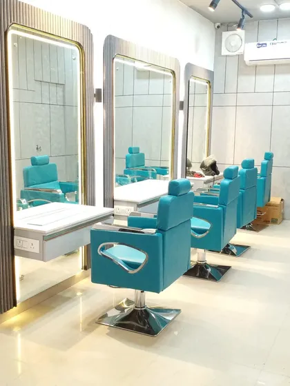 The vibrant cutting stations at the Faridabad salon. The client wanted a pop of color, so we used these beautiful turquoise chairs, which stand out against the fluted mirror panels and clean, modern finishes.