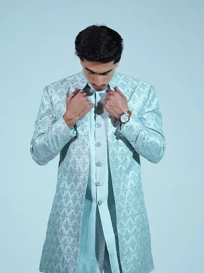 A close-up of the light blue sherwani, showing the detailed embroidery and the quality of the fabric.