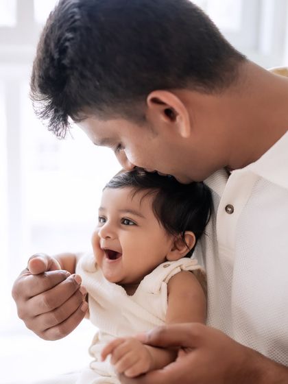 A close-up of a father kissing his baby's head. A simple and powerful expression of love.