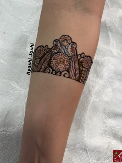 A close-up of the armband from the "Hinge" love story design, featuring two parrots amidst floral patterns.