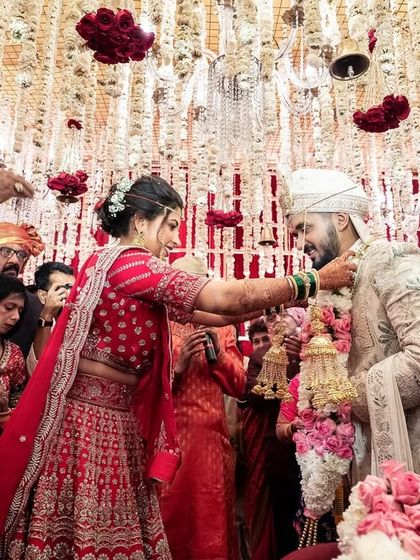 A moment to remember. The bride places the varmala on the groom under a shower of flowers.