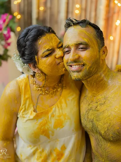 A sweet kiss amidst the yellow hues of the Haldi. A romantic moment in the middle of all the fun.