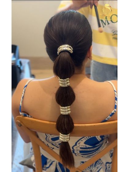 A detailed shot of the bubble braid in progress. This style is clean, graphic, and makes a real statement, especially with the right accessories.