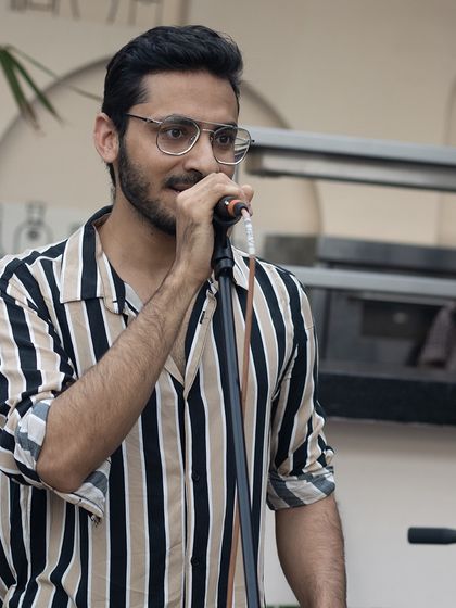 A singer pouring his heart out during his performance. The open mic is a space for genuine, heartfelt expression.
