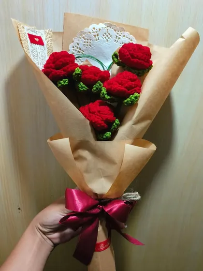 A different angle of the five-rose bouquet, showing the rich red color of the crochet flowers and the thoughtful packaging details.